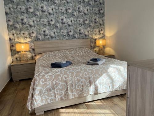 a bedroom with a bed and two night stands with lamps at Casa Alfa in Castelsardo