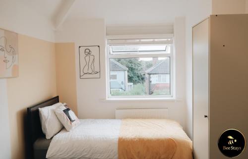 1 dormitorio con cama y ventana en Bee Stays - Caldecott House, en Mánchester
