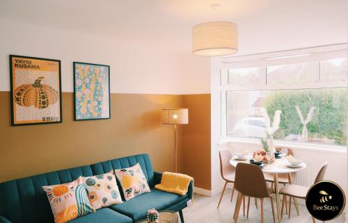 Bee Stays - Caldecott House في مانشستر: غرفة معيشة مع أريكة زرقاء وطاولة