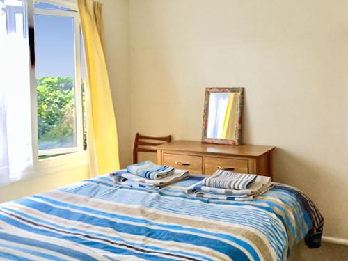 a bedroom with a bed with a window and a dresser at Sea Breeze-uk39813 in Welcombe