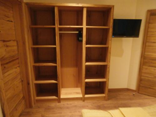 a closet with wooden shelves and a flat screen tv at Appartementhaus Gretzel in Wagrain