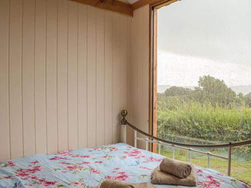 a bedroom with a bed with a large window at The Cider Pressers Hut-uk39773 in Trefeglwys