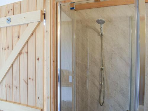 a shower with a glass door next to a staircase at The Cider Pressers Hut-uk39773 in Trefeglwys