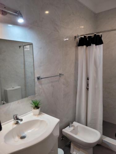 y baño blanco con lavabo y ducha. en Apartamento en el centro de Lomas en Lomas de Zamora