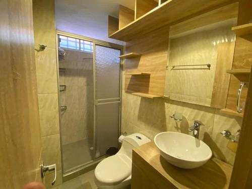 La salle de bains est pourvue de toilettes, d'un lavabo et d'une douche. dans l'établissement Hermoso Aparta estudio amoblado en Pereira, à Pereira