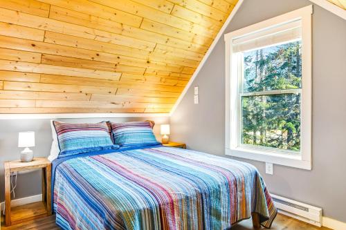 1 dormitorio con 1 cama con techo de madera en Snowdrop Summit Cabin, en Snoqualmie Pass