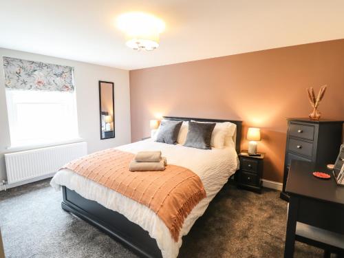 a bedroom with a large bed and a window at Printers Cottage in Alford