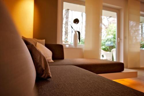a couch with pillows sitting in a living room at Designer-Loft mit Whirlpool in Cologne