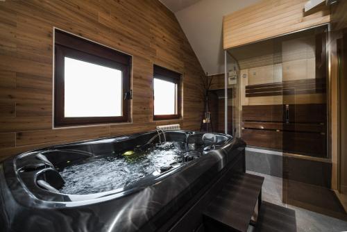 a large black tub in a bathroom with a window at Villa Inverno & Spa in Kolašin