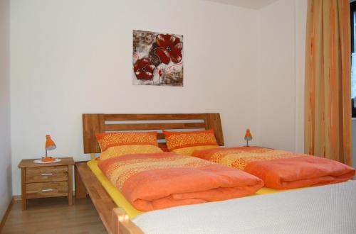 a bedroom with two beds with orange pillows on them at Ferienwohnung Marketa in Bayerisch Eisenstein