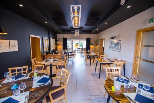 a dining room with wooden tables and chairs at Hotel L'Escapade in Balâtre