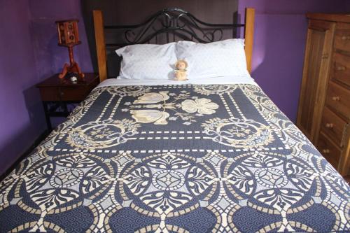 a bed with a teddy bear sitting on top of it at Casa Jardín in Guanajuato