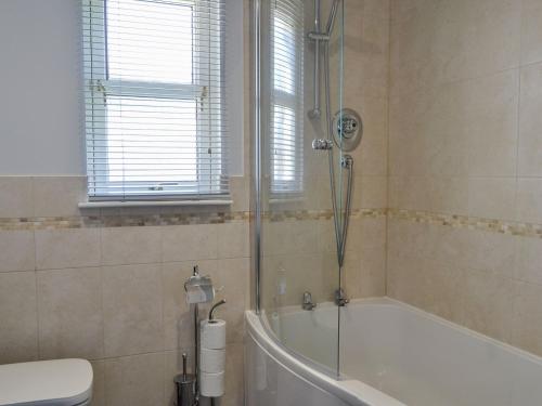 a bathroom with a shower and a tub and a toilet at Queens View Lodge in Inchmarlo