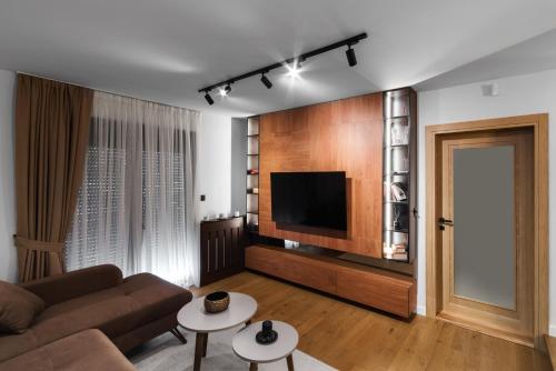 a living room with a couch and a flat screen tv at Villa Inverno & Spa in Kolašin
