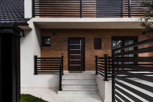 a house with a black door and a fence at Villa Inverno & Spa in Kolašin