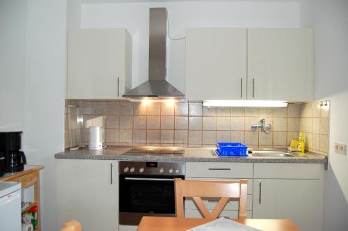 a kitchen with white cabinets and a stove top oven at Ferienwohnung Marketa in Bayerisch Eisenstein