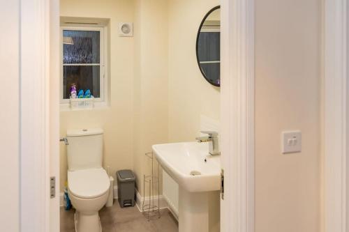a bathroom with a toilet and a sink and a mirror at Cozy 3 bed Sasha house in Beeston Nottingham in Nottingham