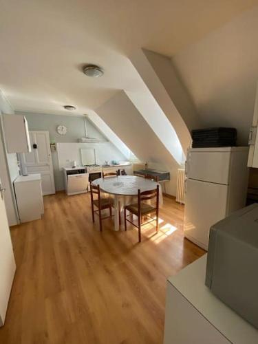 een keuken met een tafel en stoelen in een kamer bij Appartement 4-6 personnes calme proche centre-ville SLT in La Bourboule