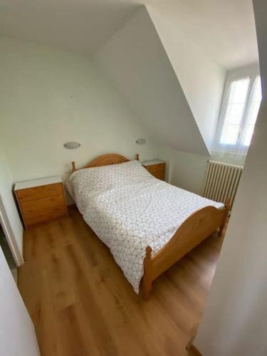 een slaapkamer met een bed en een houten vloer bij Appartement 4-6 personnes calme proche centre-ville SLT in La Bourboule