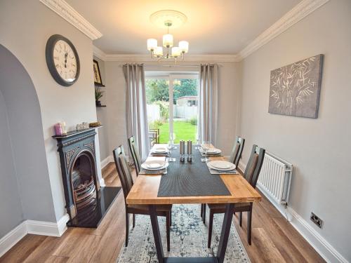 a dining room with a table and a fireplace at Cosy 3 bed with Parking- Family and Contractors in Birmingham