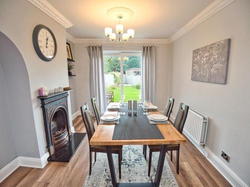 a dining room with a table and a fireplace at Cosy 3 bed with Parking- Family and Contractors in Birmingham