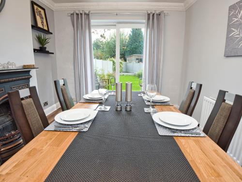 a dining room with a wooden table with chairs and a tableastery at Cosy 3 bed with Parking- Family and Contractors in Birmingham