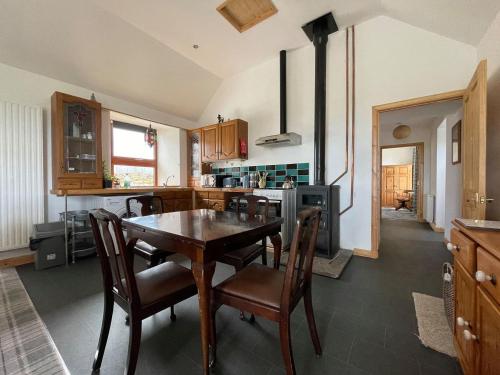 a kitchen with a table and chairs and a stove at Mey Bee in Mey