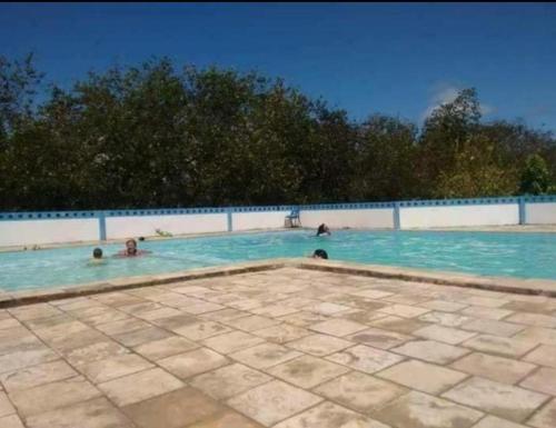 een groep mensen die zwemmen in een zwembad bij Apt mar de são josé in São José da Coroa Grande