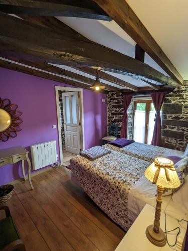 a bedroom with a bed with purple walls at Casa do Estevo in Francos