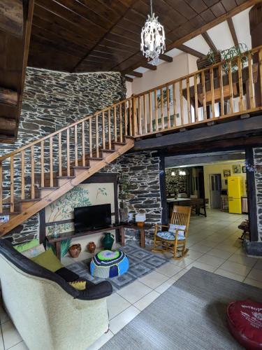 a living room with a staircase and a stone wall at Casa do Estevo in Francos