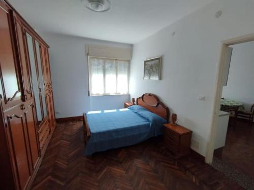 a bedroom with a blue bed and a window at Ospedaletti bilocale a due passi dal mare in Ospedaletti