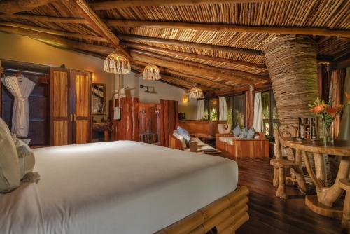 - une chambre avec un lit dans une pièce dotée de plafonds en bois dans l'établissement Kanan Tulum Treehouse, Rooftop, Beach Club & Spa - Adults Only, à Tulum