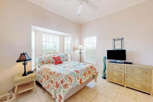 a bedroom with a bed and a dresser and a tv at Southern Belle in St. George Island