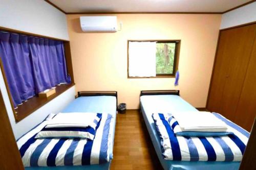two beds in a small room with a window at Atorie Bekkan - Vacation STAY 13448 in Shiozawa
