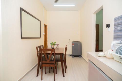 a dining room with a table and chairs in a kitchen at Adorable 2-bedroom home with Pool, Wi-Fi and BBQ in Rembau