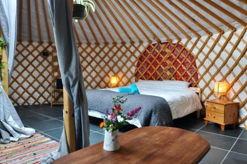 1 dormitorio en una yurta con cama y mesa en Unique underfloor heated Yurt with Hot tub, en Bow Street