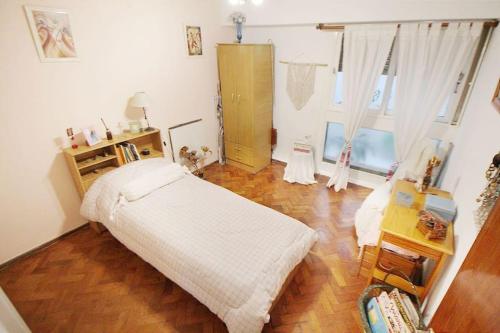 1 dormitorio con 1 cama y suelo de madera en Departamento muy buena ubicacion en Buenos Aires