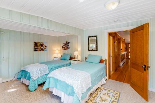 two beds in a bedroom with blue walls at Lakefront Retreat in Naples