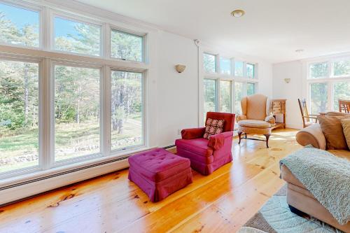a living room filled with furniture and large windows at Sweet Berry Farm in Jamaica