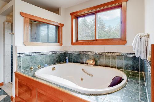 a bath tub in a bathroom with windows at Sweet Berry Farm in Jamaica