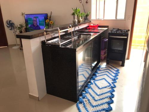 uma cozinha com um balcão com um lavatório e um fogão em Casa Cibratel 2 em Itanhaém