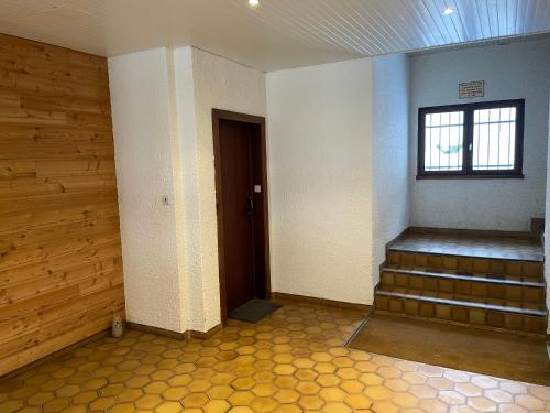 a empty room with stairs and a window at Vénosc-Les 2 Alpes , Rez de jardin in Vénosc
