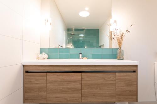 een badkamer met een wastafel en een spiegel bij The Matarangi B & B in Matarangi