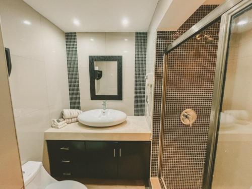 a bathroom with a sink and a shower at Cancun Plaza Condo Ocean front in Cancún