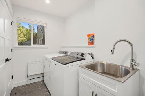 a kitchen with a sink and a stove and a sink at Elegant Old Town Charm - Walk to CSU and Downtown in Fort Collins