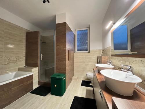 uma casa de banho com 2 lavatórios, uma banheira e um WC. em Apartment House Nová Dubnica em Nová Dubnica