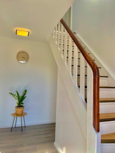 a white staircase with a plant on a table at FRIESENHÜTTE NORDDEICH in Norddeich