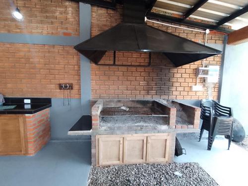 - une cuisine avec un grill dans un mur en briques dans l'établissement Kuri Hospedaje Turístico, à Puerto Iguazú