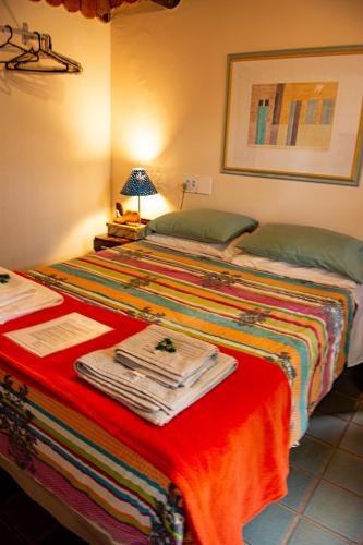 a bedroom with two beds and a red blanket at Aconchego Itaipava in Petrópolis