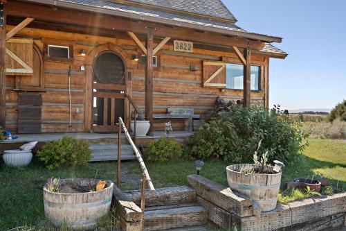 una cabaña de madera con algunos escalones delante de ella en Lindas Perch by KABINO On Bank of Henrys Fork Mtn Views Fishing 6 acres Snake River WIFI, en Ashton